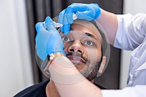 Ophtalmologist dropping eye drops to patients eyes