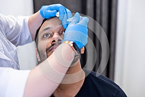 Ophtalmologist dropping eye drops to patients eyes photo