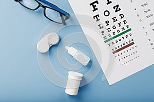 Ophthalmic Accessories Glasses and lenses with an Eye Test Chart for vision correction on a blue background