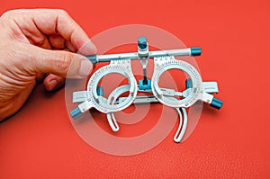 Ophthalmological device for selecting glasses. Correction improvement of vision. Red background photo