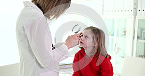 Ophthalmologist checks eye of small child or performs postoperative examination using special equipment