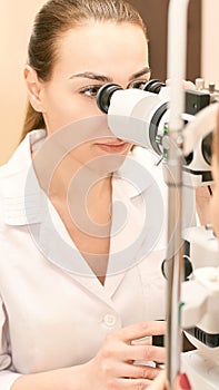 Ophthalmologist doctor in exam optician laboratory with female patient. Eye