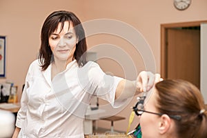 Ophthalmologist doctor in exam optician laboratory with female patient. Eye care