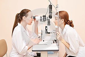 Ophthalmologist doctor in exam optician laboratory with female patient. Eye care