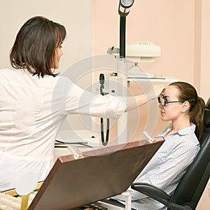 Ophthalmologist doctor in exam optician laboratory with female patient. Eye care medical diagnostic. Eyelid treatment