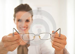 Ophthalmologist doctor woman giving eyeglasses
