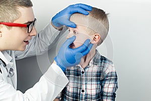 An ophthalmologist examines a boy who complains of burning and pain in his eyes. Eye fatigue from a computer or phone screen