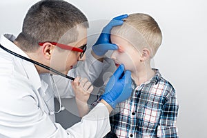 An ophthalmologist examines a boy who complains of burning and pain in his eyes. Eye fatigue from a computer or phone screen