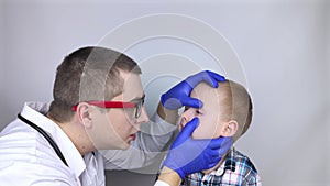 An ophthalmologist examines a boy who complains of burning and pain in his eyes. Eye fatigue from a computer or phone screen sens