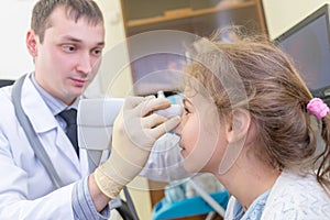 ophthalmologist examines the eyes of a teenage