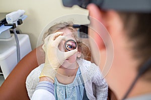 ophthalmologist examines the eyes of a teenage