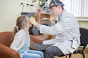 ophthalmologist examines eyes of a teenage girl