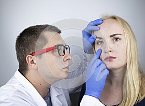 An ophthalmologist examines a woman who complains of a burning sensation and pain in her eyes. Eye fatigue from a computer screen