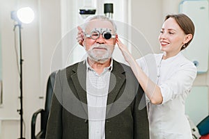 ophthalmologist makes selection of lenses, diagnoses a elderly man's vision.