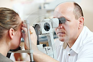 Ophthalmologist or optometrist optician at work photo