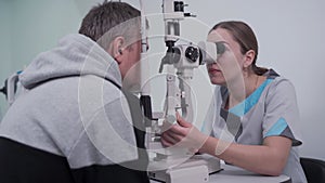 Ophthalmologist and patient testing eyesight. Man doing eye test with optometrist. Ophthalmologist using apparatus for