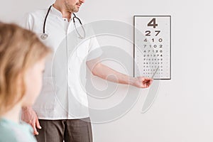 Ophthalmologist shows a boy an eye test chart