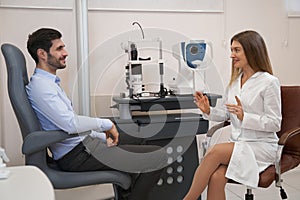 Ophthalmologist talking to male patient at the table