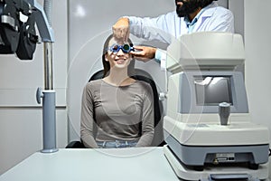 Ophthalmologist testing vision or sight of female patient for glasses in a clinic. Health care, medicine, eye sight