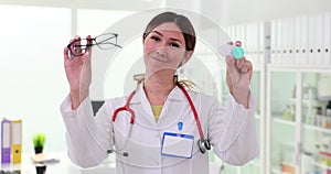 Ophthalmologist woman holding contact lenses and glasses