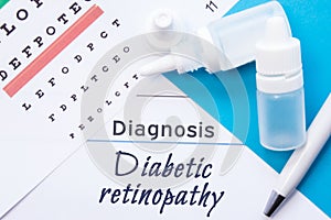 Ophthalmology diagnosis Diabetic retinopathy. Snellen eye chart, two bottles of eye drops medications lying on notebook with photo