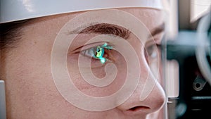 Ophthalmology treatment - a young woman checking her visual acuity - checking a reaction on the green light