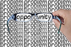 Opportunity spotted among problems hands holding glasses focusing on opportunity word. Concept image