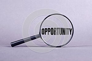 Opportunity word in black letters under magnifier on light purple background