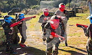 Opposing teams of sports kids shooting paintball