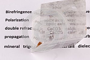 Optical birefringence demonstrated using a text using a natural double spar calcite crystal photo