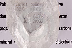 Optical birefringence demonstrated using a text using a natural double spar calcite crystal photo