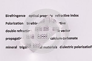 Optical birefringence demonstrated using a text using a natural double spar calcite crystal photo