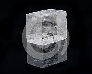 Optical Calcite from China isolated on a black mirror background. Alternative stone name: Iceland Spar