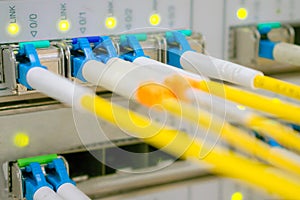 Optical fiber wires are connected to high-speed interfaces. Lots of yellow internet cables. Front panel of the central router with