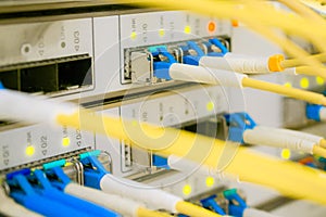 Optical fiber wires are connected to high-speed interfaces. Many yellow internet cables.Front panel of the central router with a