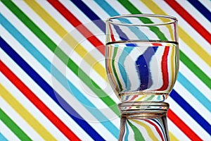 Oblique lines of colors reflected in a glass of water photo