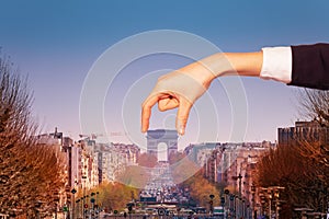 Optical illusion of hand holding Arc de Triumph photo