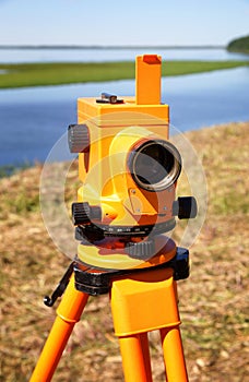 Optical level close-up against the background of a river valley