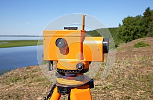 Optical level close-up against the background of a river valley and taiga