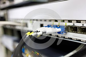 Optical patch cords are inserted into the switch in the server room