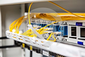 Optical patch cords in patch panel. Wiring. Patch panel. The wires are yellow-white. Horizontal orientation.