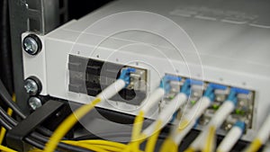 Optical server and router of the data center server room. Network equipment blinking with lights on rack. Optical fiber