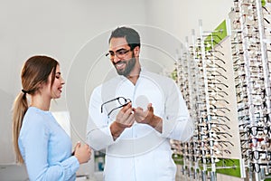 Optical Store. Eye Doctor Helping Woman Choosing Eyeglasses