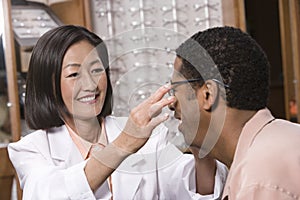 Optician Assisting Male Patient