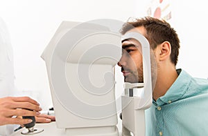 Optician with autorefractor and patient at clinic