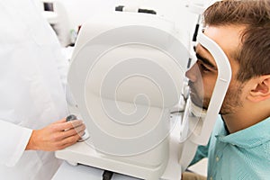 Optician with autorefractor and patient at clinic