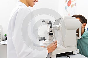 Optician with autorefractor and patient at clinic