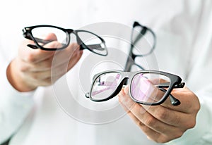 Optician comparing lenses or showing customer different options