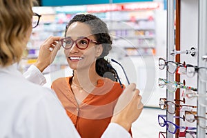 Optician comparing spectacles with client