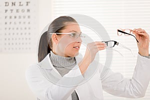 Optician doctor woman with glasses and eye chart